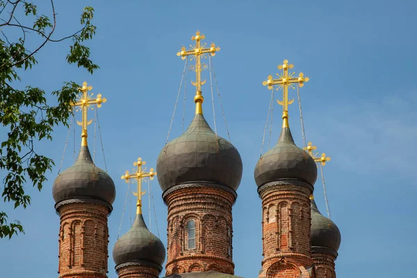 青い空に対して古い正統派教会の黄金の十字架と黒のドーム — ストック写真