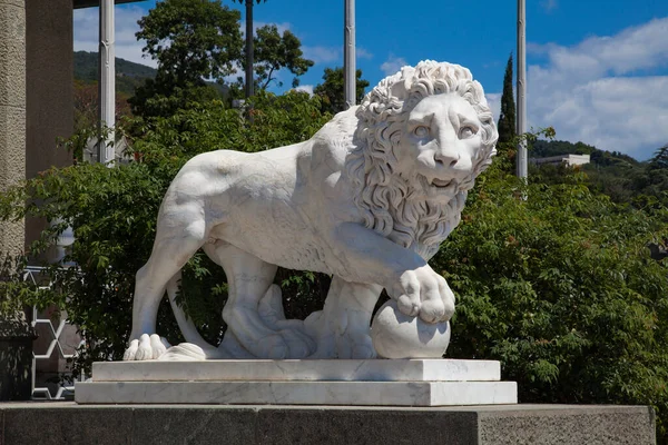 ALUPKA, CRIMEA - 03 Ağustos 2020 Vorontsov Sarayı 'na girmeden önce patisini topa koyan bir aslanın mermer heykeli