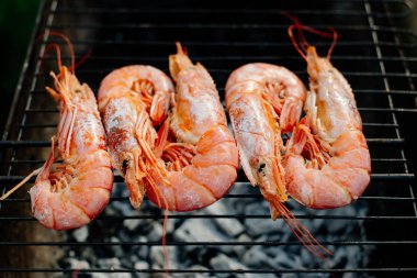 Bilinenlerin ve karides ızgara. Kadın karides forseps Şef maşa ile döner, yarım limon suyu ile sprinkles