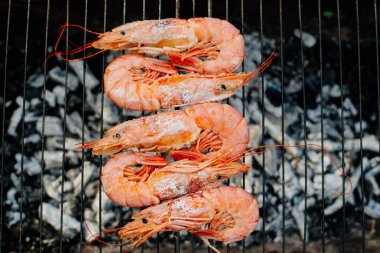 Bilinenlerin ve karides ızgara. Kadın karides forseps Şef maşa ile döner, yarım limon suyu ile sprinkles