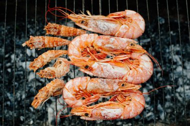 Bilinenlerin ve karides ızgara. Kadın karides forseps Şef maşa ile döner, yarım limon suyu ile sprinkles