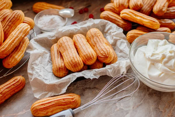Ev yapımı eklerleri. Eklerleri ev mutfakta hazırlanması. Eklerleri pişirme süreci. Pasta bir küçük, yumuşak, günlük şeklinde Pasta krema ile doldurulmuş ve genellikle çikolata sosu ile tepesinde.