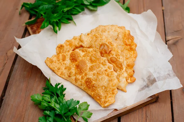 Chebureks pişirme süreci. Beyaz ve Doğu doldurulmuş kuzu ve baharatlı çeşnilikler ile ince mayasız hamur yapılmış bir patty besindir. Cheburek - et ve soğan ile kızarmış pasta.