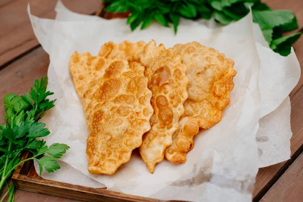 Chebureks pişirme süreci. Beyaz ve Doğu doldurulmuş kuzu ve baharatlı çeşnilikler ile ince mayasız hamur yapılmış bir patty besindir. Cheburek - et ve soğan ile kızarmış pasta.