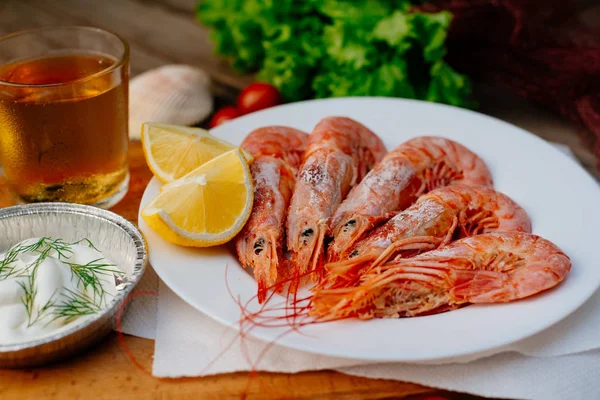 Bilinenlerin ve karides ızgara. Kadın karides forseps Şef maşa ile döner, yarım limon suyu ile sprinkles