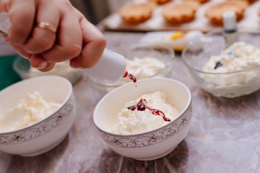 Turta kekleri için tereyağlı krema. Turtalar için krem rengi krema yapma süreci. Krem gıda boyasıyla lekelenmiş. Krem şanti. Pasta poşetlerinde krema.