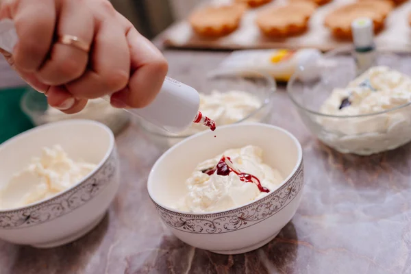 Turta kekleri için tereyağlı krema. Turtalar için krem rengi krema yapma süreci. Krem gıda boyasıyla lekelenmiş. Krem şanti. Pasta poşetlerinde krema.