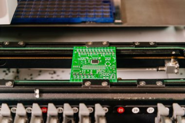 Yazılı devre kartı. Yazılı bir devre kartı oluşturma süreci. Yazılı devre kartları ve mikro devreler üreten bir robot..