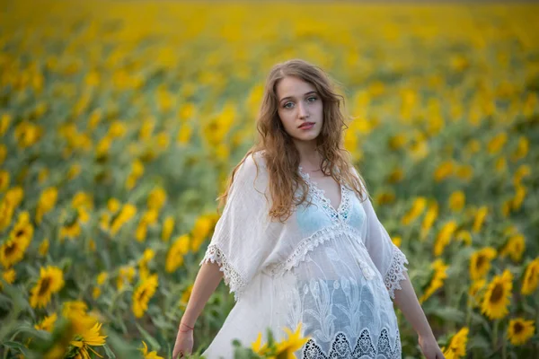 美しいです若いです女の子ポーズで夕日でひまわり畑 — ストック写真