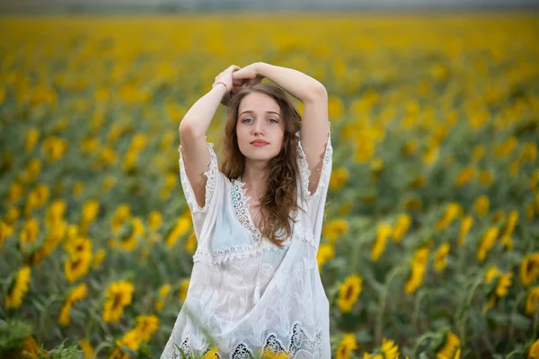 美しいです若いです女の子ポーズで夕日でひまわり畑 — ストック写真