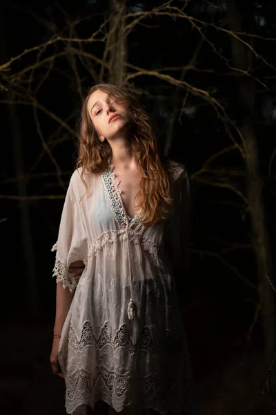 美丽的年轻女子在一片漆黑的森林里摆姿势 — 图库照片