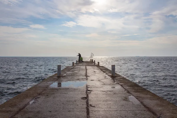 Balıkçı Şafakta deniz iskelede. Odesa şehri. Ukrayna
