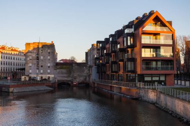 Gün batımında Wroclaw şehrindeki nehir setinin manzarası. Polonya