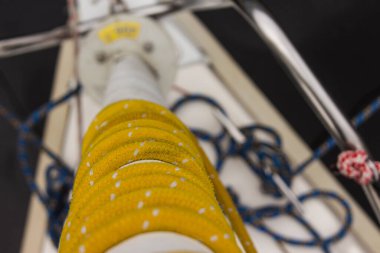 Sarı halat yelkenli bir yatta yelkenliye sarılmış.