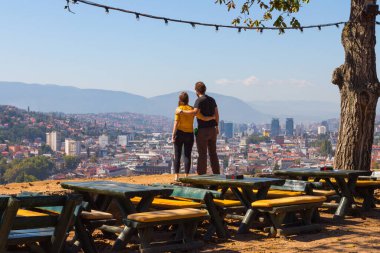 Tepeden Saraybosna şehrine bakan genç bir çift. Bosna-Hersek