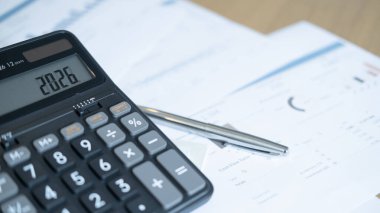Financial charts and calculator displaying 2026, representing economic forecast, business strategy, and long-term financial planning.