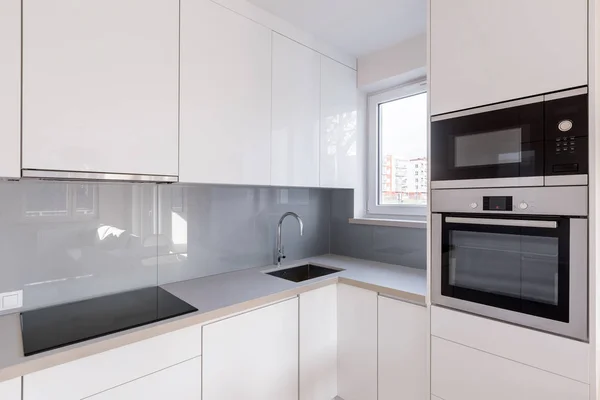 Moderne Küche Mit Weißen Schränken Hochglanzfliesen Und Neuer Mikrowelle Und — Stockfoto