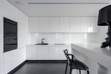 Sophisticated black and white kitchen interior with simple table and chair