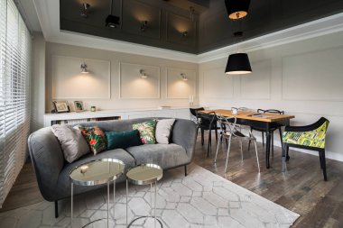 Gri kanepe, bej duvarlar ve siyah streç tavan ile oturma odası