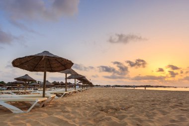 Şezlong ve şemsiyeleri sahilde günbatımı, Sal, Cape Verde, Cabo Verde sırasında