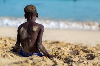 Boy sitting on the beach of Sal island, Cabo Verde, Cape Verde