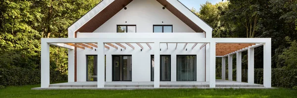 現代的な 白い家の外観と木製の天井と裏庭のベランダのパノラマ — ストック写真