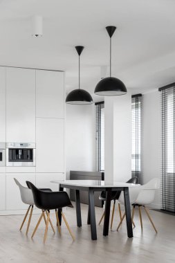 Modern masalı şık bir yemek salonu ve birçok penceresi olan mutfaktaki sandalyeler.
