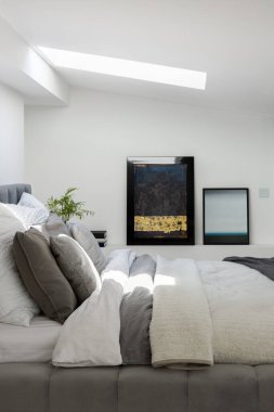 Zarif beyaz yatak odası, büyük yatak odası, sanat eseri ve tavan penceresi.