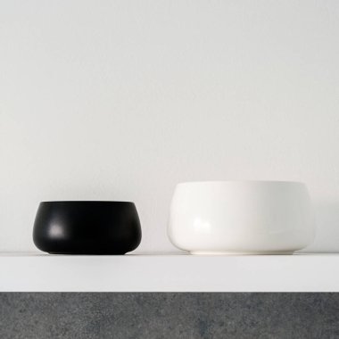 İkiye yakın plan, modern, siyah ve beyaz kaseler beyaz mutfak rafında.