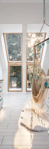 Vertical panorama of modern attic room with window and stylish hammock seat