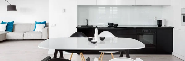 一幅幅白色的现代餐桌全景 厨房里有黑白色的椅子 通向客厅 — 图库照片