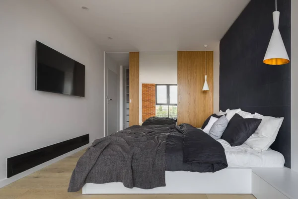 Eenvoudige Slaapkamer Met Groot Bed Donkere Gestoffeerde Muur Kledingkast Achter — Stockfoto