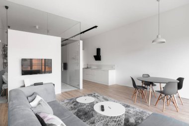 Mutfağı, oturma odası ve yemek odası olan şık beyaz bir daire.