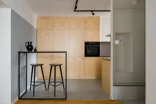 Moderne Küche Mit Birkensperrholzschränken Schwarzem Tisch Mit Hohen Barhockern Und — Stockfoto