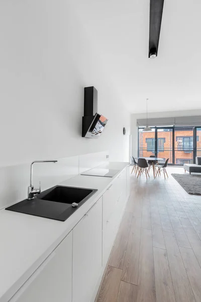 Eenvoudige Keukenhoek Met Lange Witte Aanrecht Witte Kasten Zwarte Spoelbak — Stockfoto