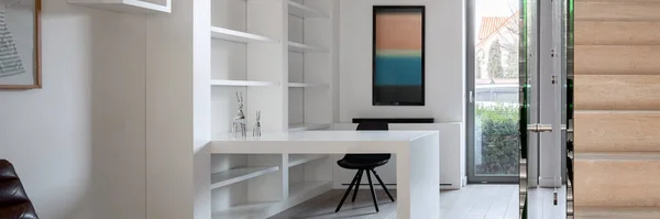 白い棚 壁と机と木製の階段を持つシンプルなホームオフィスのパノラマ — ストック写真