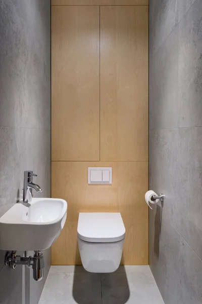 简单的浴室 灰色地面和墙砖 小盥洗盆和厕所后面的木制墙壁 — 图库照片