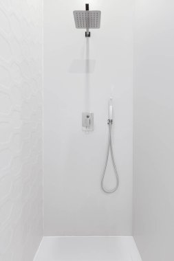 Altıgen şekilli kiremitleri ve gümüş muslukları olan modern ve zarif bir duş.