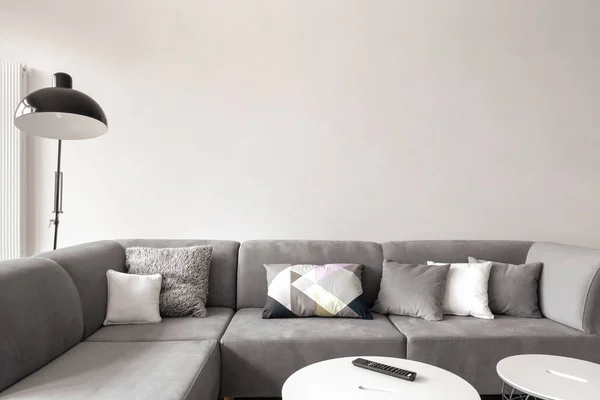 大而舒适的灰色角落沙发 配有装饰枕头和两张白色咖啡桌 — 图库照片