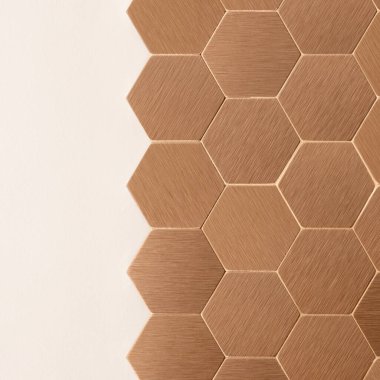 Şık bakır, altıgen şekilli duvar döşemeleri ve basit beyaz duvara yakın plan.