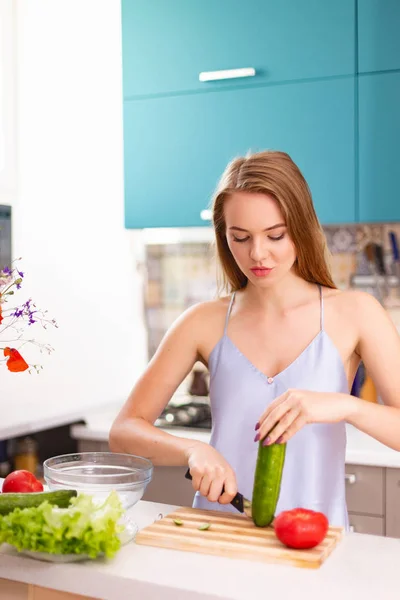 Schönes Mädchen macht Salat in der Küche — Stockfoto