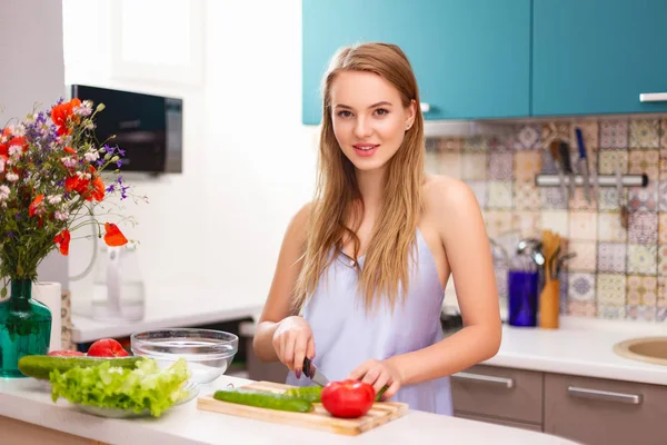 Hermosa chica haciendo ensalada en la cocina —  Fotos de Stock