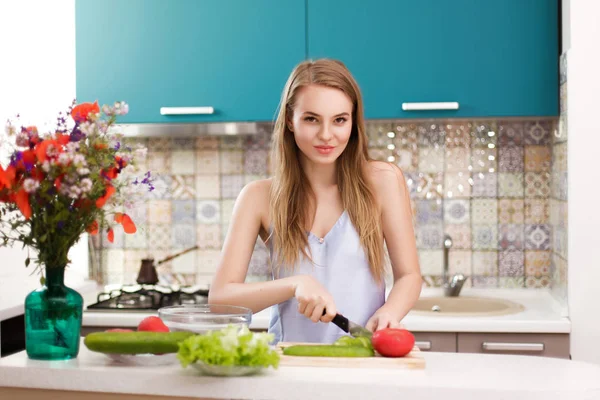 Piękna dziewczyna robi sałatkę w kuchni — Zdjęcie stockowe
