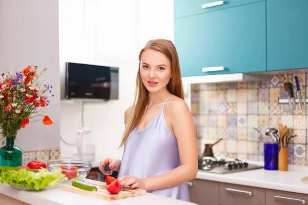 Mooi meisje maken salade in de keuken — Stockfoto