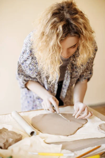 Young girl is cutting clay — Stock Photo, Image