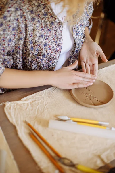 Manos femeninas hacen un plato de arcilla —  Fotos de Stock