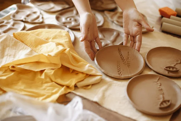 Γυναικεία χέρια φτιάχνουν ένα πιάτο πηλό — Φωτογραφία Αρχείου
