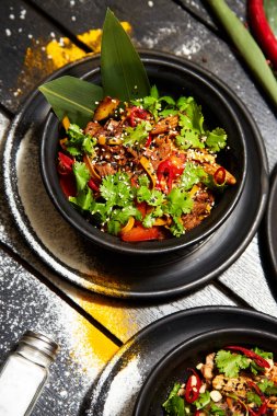 Siyah bir tabakta Asya yemeği. Sığır eti ile Erişte