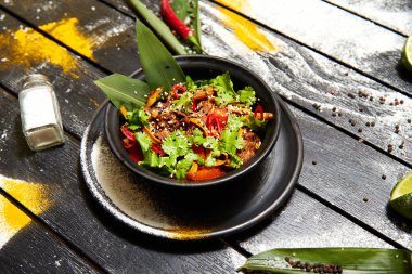 Siyah bir tabakta Asya yemeği. Sığır eti ile Erişte