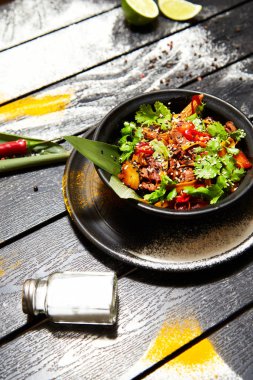 Siyah bir tabakta Asya yemeği. Sığır eti ile Erişte